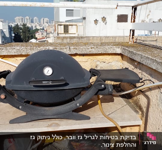 גריל גז שחור עם מד חום על שולחן מרפסת